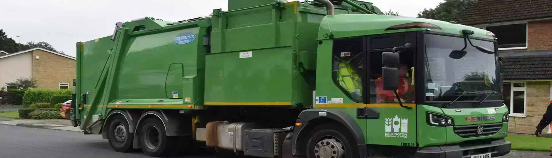 Large green bin truck collecting refuse in Darlington
